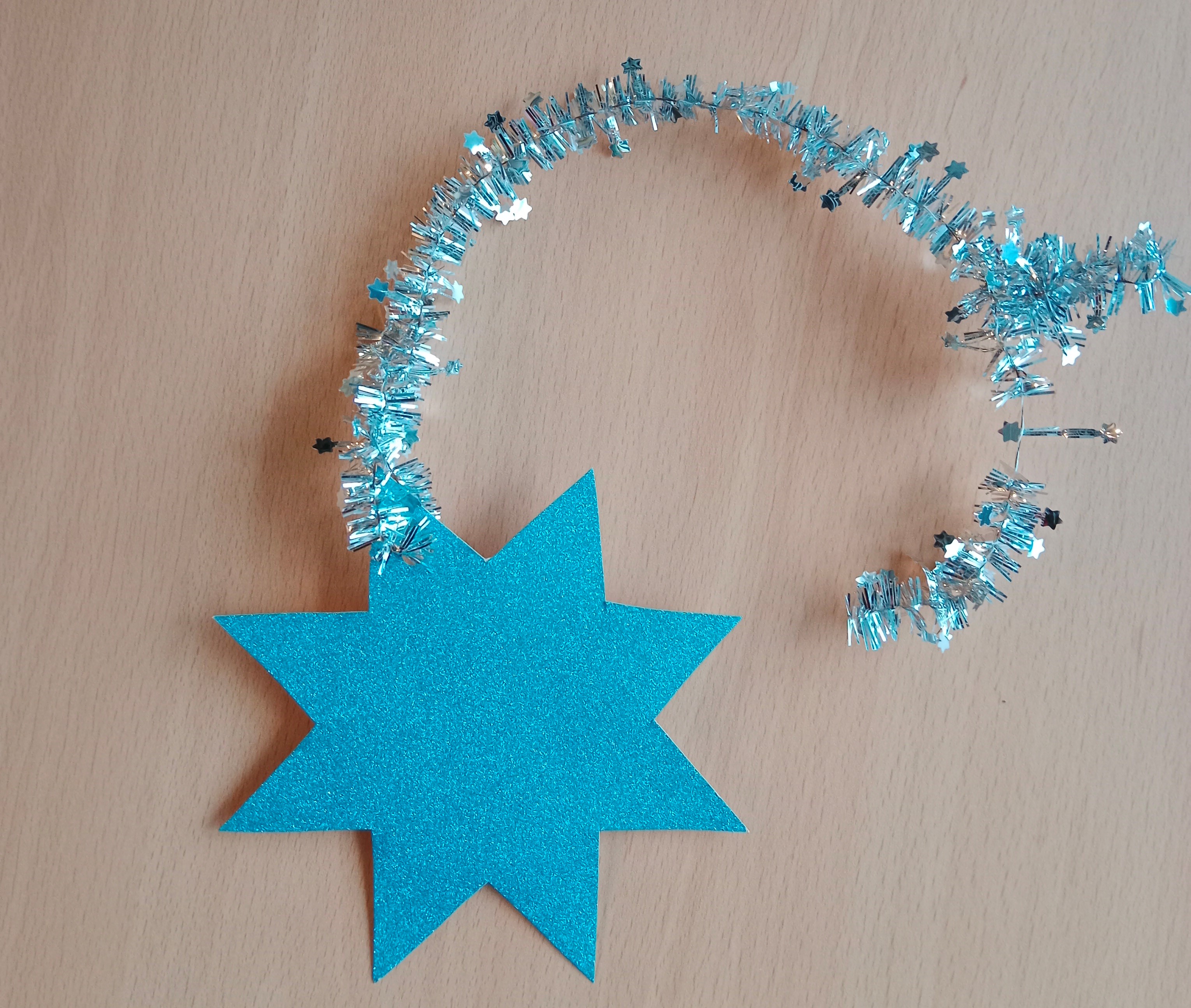 Stern aus blauer Glitzerpappe mit silbernem Band